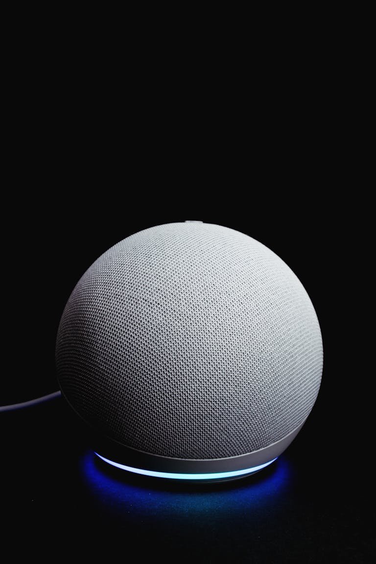 A stylish smart speaker glowing on a dark background, showcasing modern technology.