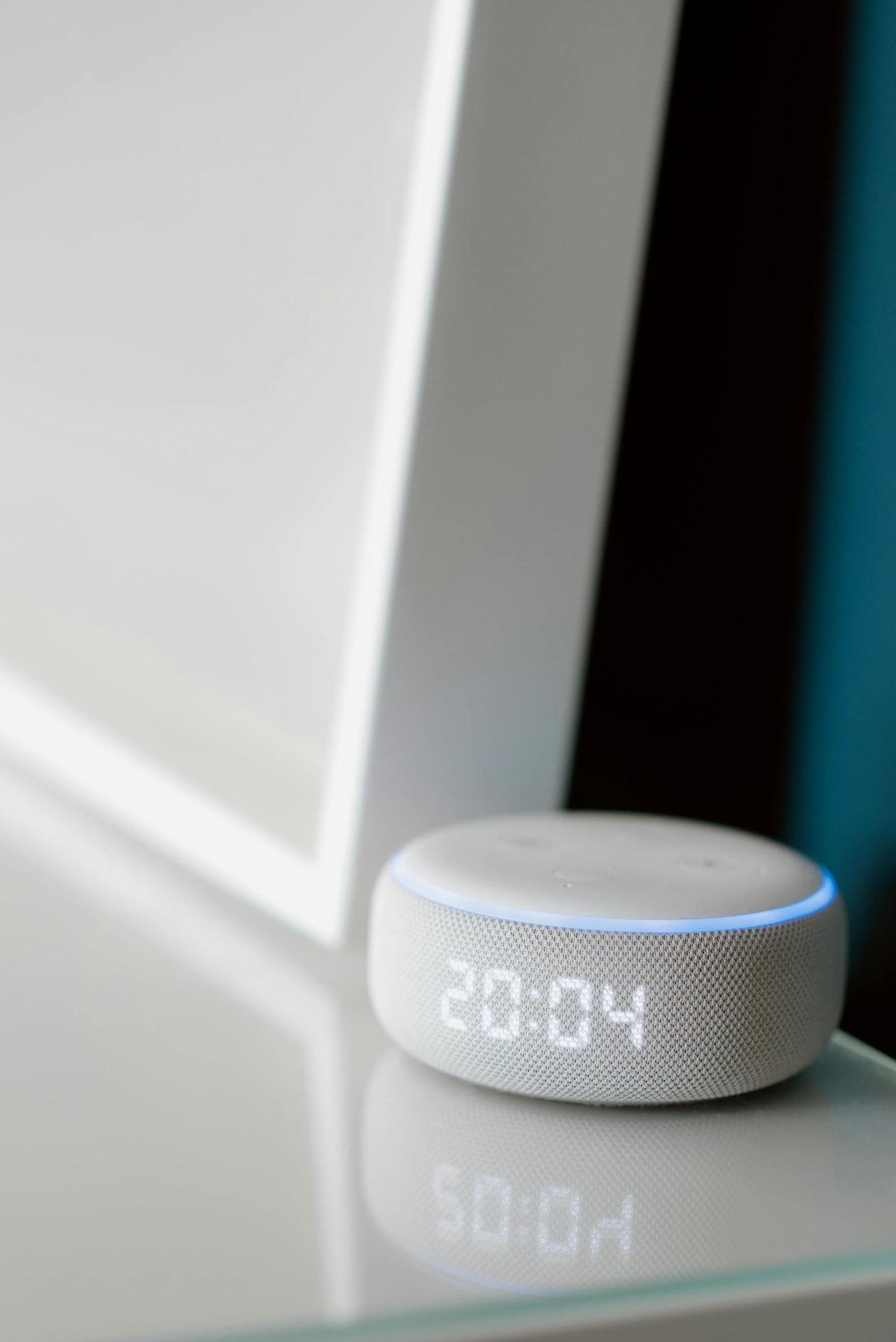 Close-up of a smart speaker with digital time display indoors.